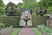 Une fontaine au centre d'un jardin bord de murs