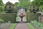Une fontaine au centre d'un jardin bord� de murs